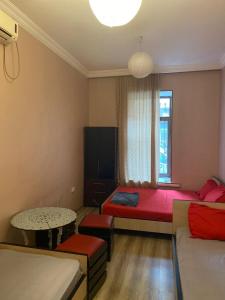a room with two beds and a table in it at ARTISHA TRAVEL TBILISI in Tbilisi City