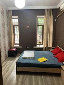 a bedroom with a blue bed and red pillows at ARTISHA TRAVEL TBILISI in Tbilisi City