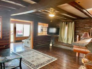 a living room with a flat screen tv on the wall at Restored historic log cabin & deck on Lake Erie in Luna Pier