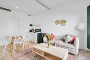 Sala de estar blanca con sofá y mesa en Palacio de Bobadilla Suites, en Cuenca