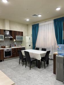 a kitchen and dining room with a table and chairs at AQ Capsule Hostel in Almaty