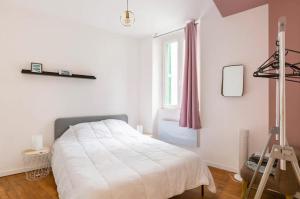 biała sypialnia z łóżkiem i drabiną w obiekcie Escapade dans grand T2 de charme avec terrasse - Proche Gare et Centre ville w Lourdes
