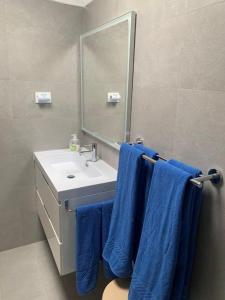 a bathroom with blue towels hanging over a sink at Casa Torres in San Bartolomé de Tirajana