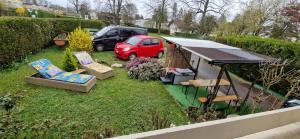 mały ogródek z czerwonym samochodem zaparkowanym na podwórku w obiekcie Maison des pilotes w Genewie