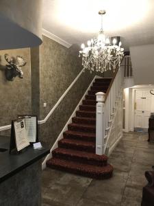 a staircase with a chandelier in a room at The Sun Hotel in Warkworth