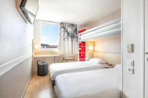 Rúm í herbergi á B&B HOTEL Lyon Aéroport Saint-Quentin-Fallavier