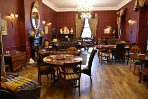 a restaurant with tables and chairs and a chandelier at The Sun Hotel in Warkworth