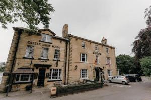 a large brick building with a car parked in front of it at The Sun Hotel in Warkworth