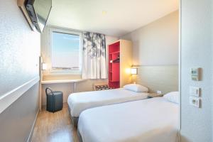 Rúm í herbergi á B&B HOTEL Lyon Aéroport Saint-Quentin-Fallavier