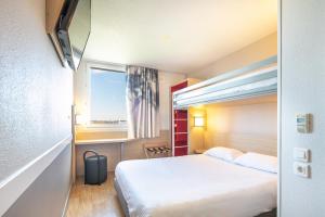 um quarto de hotel com uma cama e uma janela em B&B HOTEL Lyon Aéroport Saint-Quentin-Fallavier em Saint-Quentin-Fallavier