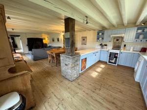 a kitchen with a stove and a table in a room at Woodbine Cottage in Studdon