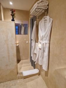 a bathroom with a shower and towels hanging on a wall at L'Oum Errebia in Azemmour