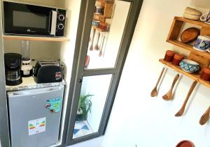 einen kleinen Kühlschrank in einer Küche mit Mikrowelle in der Unterkunft The African Story in La Marsa