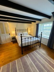 a bedroom with a bed and a large window at Woodbine Cottage in Studdon