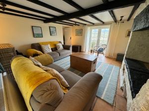 sala de estar con sofá y chimenea en Woodbine Cottage, en Studdon