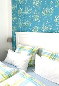 a bedroom with two beds and a blue wall at Gästehaus Teerlings Hafen in Borkum