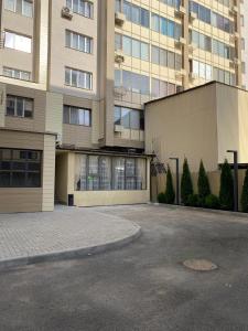 a parking lot in front of a large building at AQ Capsule Hostel in Almaty