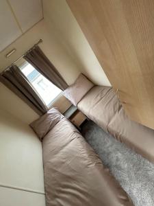 a small room with a bed and a window at 2 Bedroom Caravan Stay, Central Beach, Leysdown in Leysdown-on-Sea