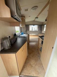 a kitchen in an rv with a counter top at 2 Bedroom Caravan Stay, Central Beach, Leysdown in Leysdown-on-Sea