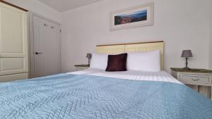 a bedroom with a large bed with a blue blanket at 5 The Burrows in Braunton