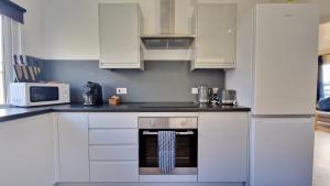 a kitchen with white cabinets and a stove top oven at 5 The Burrows in Braunton