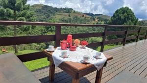 een tafel op een terras met uitzicht op een berg bij Casa Sossego na Montanha in Campos do Jordão