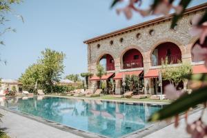 a swimming pool in front of a building at Le Greghe Suites in Lazise