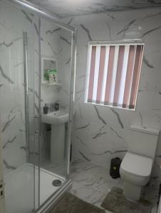 a bathroom with a shower and a toilet and a sink at Stunning 3-Bed House in Manchester in Manchester