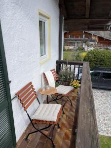 two chairs and a table on a porch at Ferienwohnung Rebensburg in Point