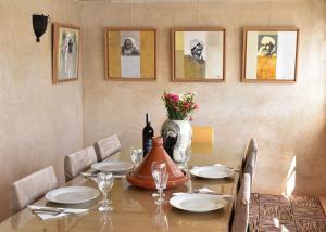 a dining room table with a bottle of wine on it at L'Oum Errebia in Azemmour