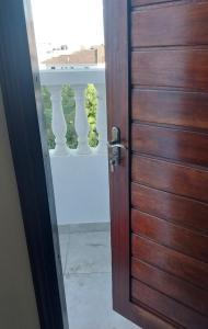 una puerta de madera abierta con vistas a un balcón en Studio Apartment Nyali en Mombasa