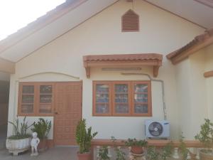 une maison avec une fenêtre et un ventilateur dans l'établissement Bualuang Country Village - Pet Friendly, à Uttaradit