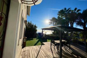 eine Terrasse mit einem Tisch und einem Sonnenschirm auf einer Terrasse in der Unterkunft Golfe Juan - Villa 4 people - Sea view - Garden in Vallauris