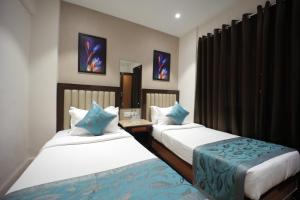 a hotel room with two beds and a mirror at The Byke Studio Pure Veg Apartment, Thane in Thane