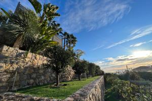 uma parede de pedra com árvores e uma palmeira em Golfe-Juan - Villa 10 people - Private Pool - Parking em Vallauris