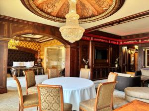 una sala da pranzo con tavolo, sedie e lampadario pendente di Royal SPA & Hotel Resort a Riga
