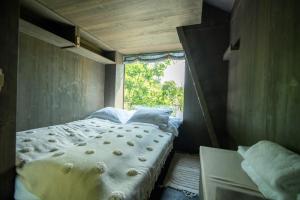 a bed in a small room with a window at Hrad Kunzov Glamping & SPA & Restaurant in Přerov