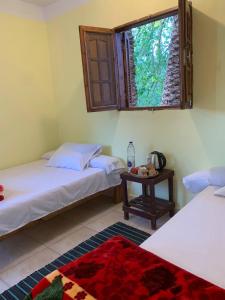 a room with two beds and a table with a window at Omar Oasis in Siwa