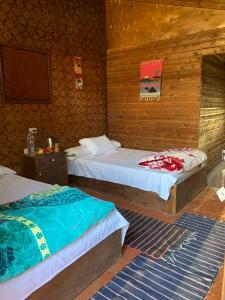 2 łóżka w pokoju z drewnianymi ścianami w obiekcie Omar Oasis w mieście Siwa