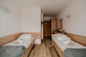 2 Betten in einem Zimmer mit Holzböden in der Unterkunft Centrum Wypoczynku i Rekreacji Rysy Krynica Zdrój in Krynica-Zdrój