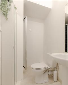 Baño blanco con aseo y lavamanos en Primrose Hill Charming 1-Bed Flat, en Londres