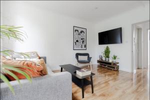 a living room with a couch and a tv at Primrose Hill Charming 1-Bed Flat in London