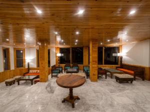 un vestíbulo con bancos y mesas en un edificio en Roomy Daastaan Hotel, Karimabad Hunza en Hunza