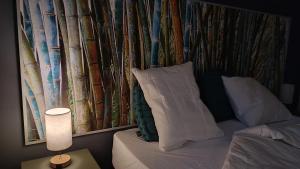 um quarto com uma cama e uma parede com árvores em Le Chant des Pierres em Saint-Pierre-des-Champs