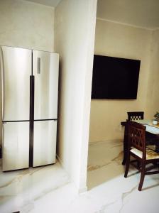um frigorífico de aço inoxidável numa cozinha com uma mesa em Palazzo in Corte - Nel cuore di Bari em Bari