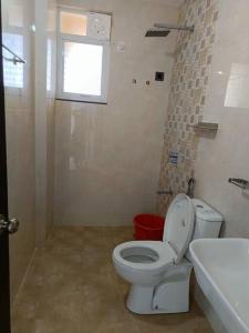 a bathroom with a toilet and a sink and a window at Zanita Heights Seaview Apt in Bogmalo