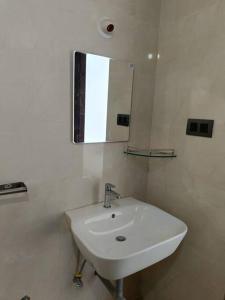 a white sink in a bathroom with a mirror at Zanita Heights Seaview Apt in Bogmalo