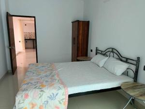 sypialnia z łóżkiem, stołem i drzwiami w obiekcie Zanita Heights Seaview Apt w mieście Bogmalo