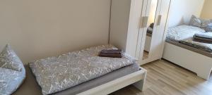 a small bedroom with a bed and a mirror at Ferienwohnung ASL in Aschersleben