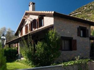 ein Steinhaus mit einem Dach und einem Hof in der Unterkunft El Olivar in Palo